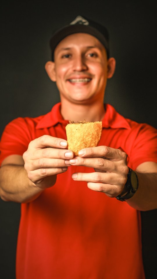 Integrante de El Arriero mostrando una empanada recién hecha